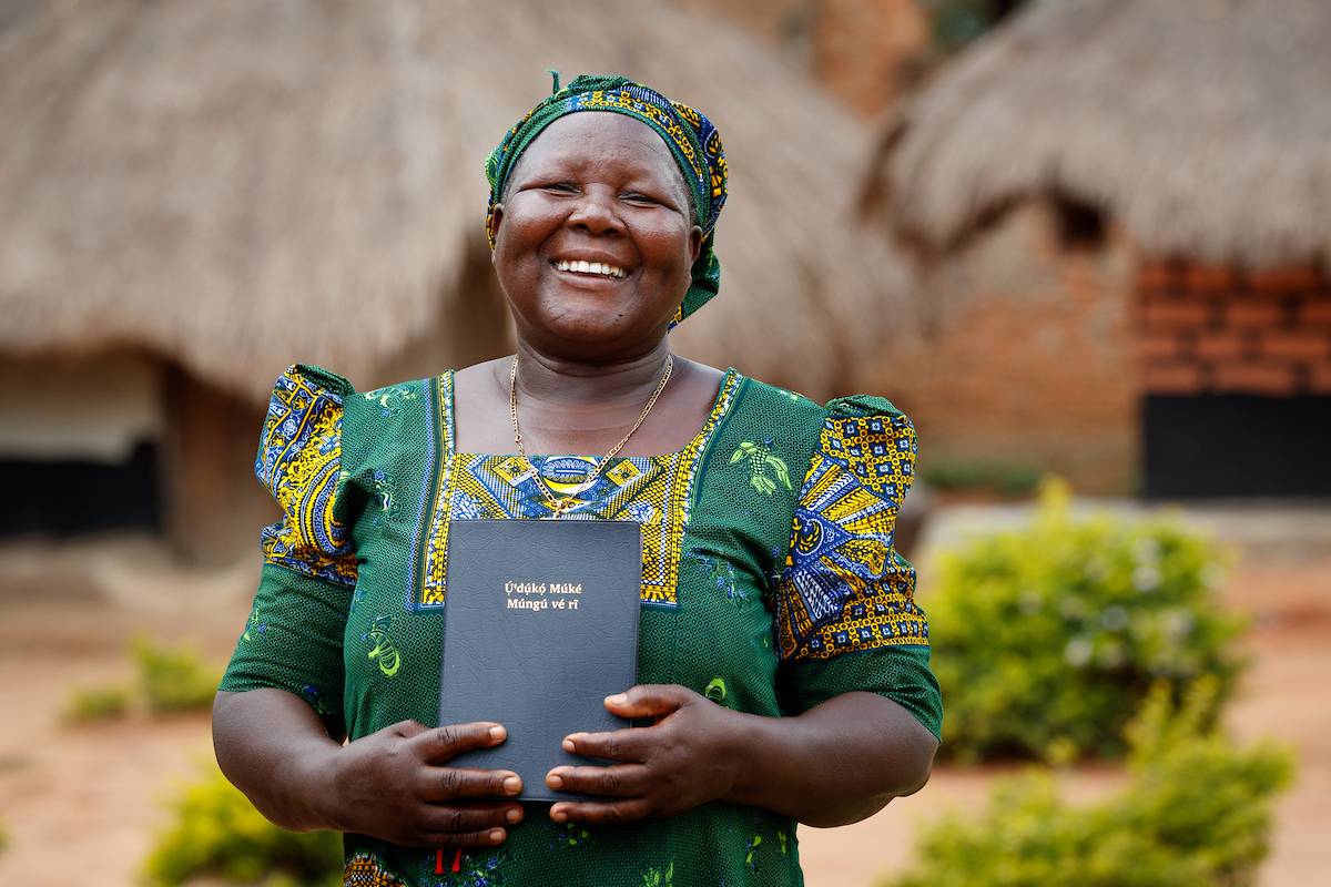 Ugandan woman holding Scripture.